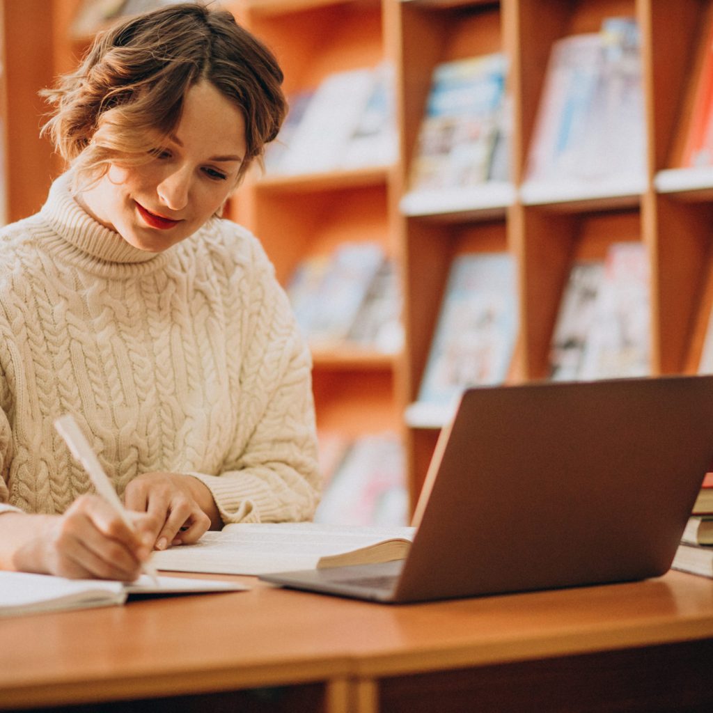 Young woman working on laptop in a library Young woman working on laptop in a library